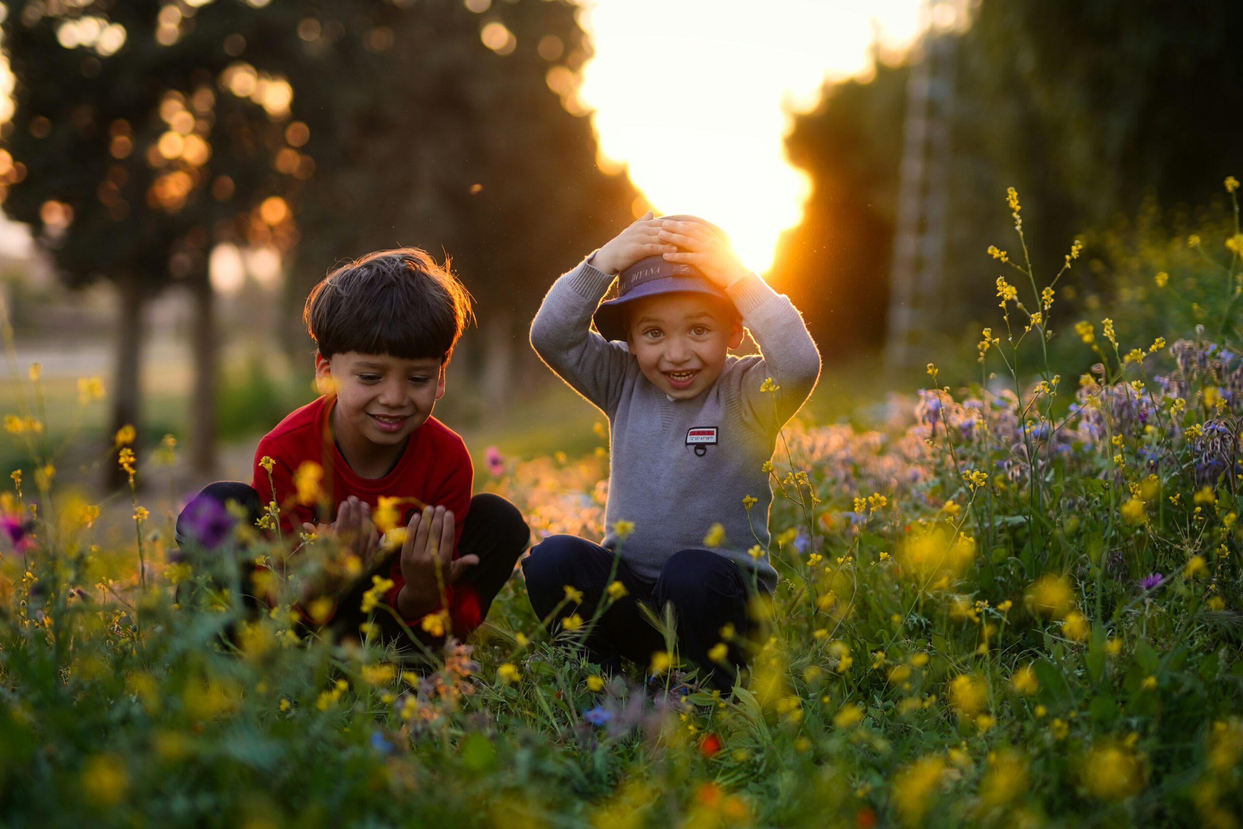 two children sitting in field